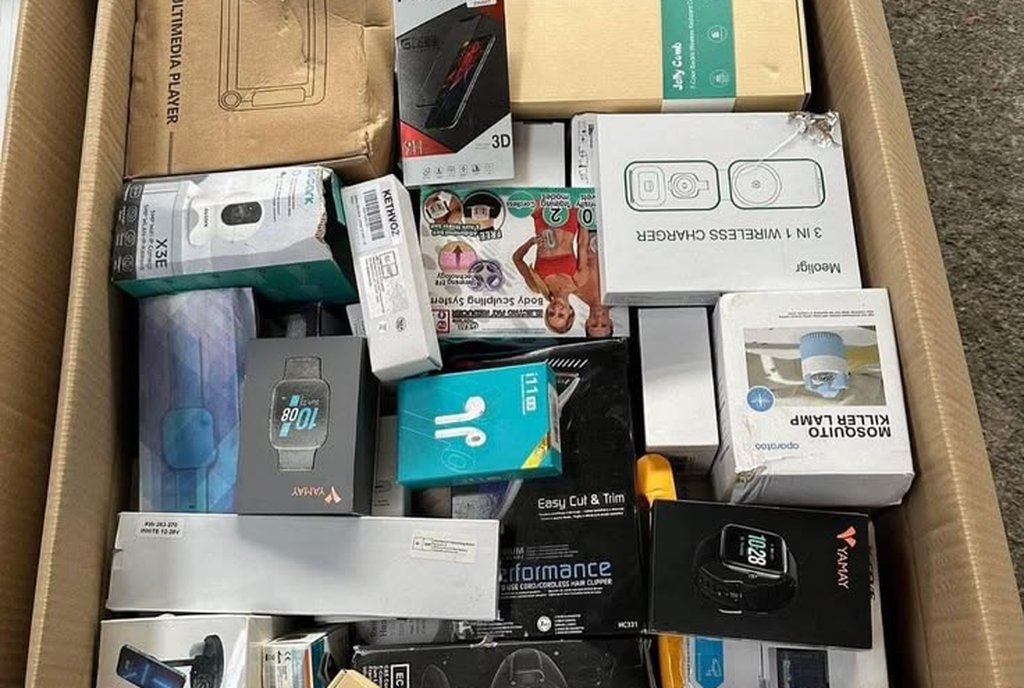 Caixa de papelão cheia de relógios inteligentes, fones e acessórios eletrônicos lacrados